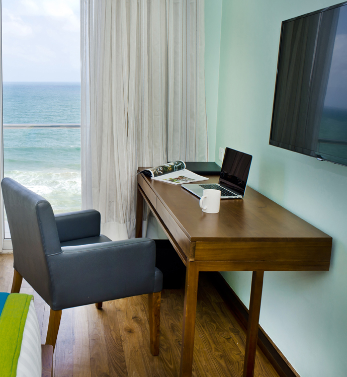 Woman reading newspaper in hotel suite.